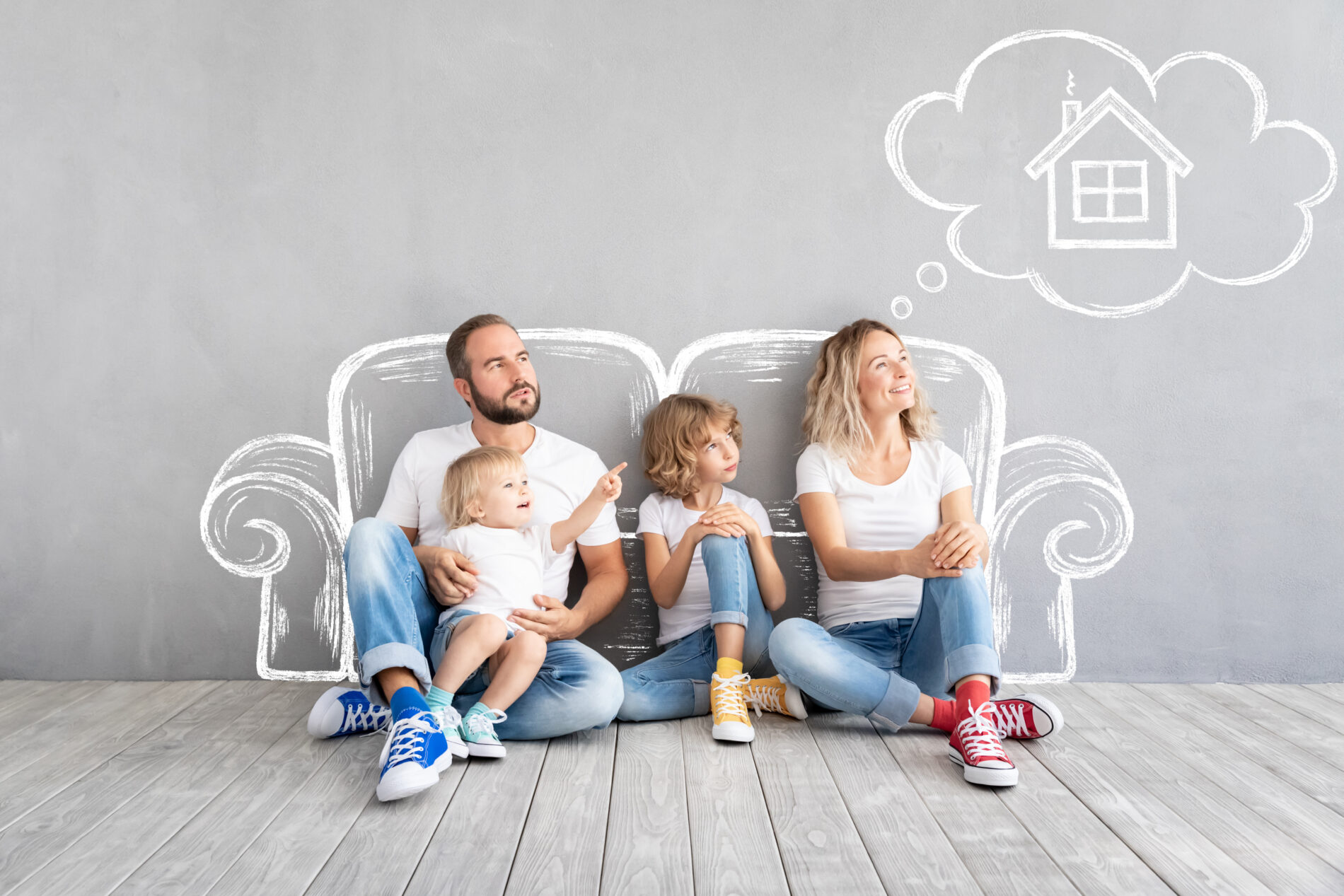 Happy family with two kids playing into new home. Father, mother and children having fun together. Moving house day and real estate concept